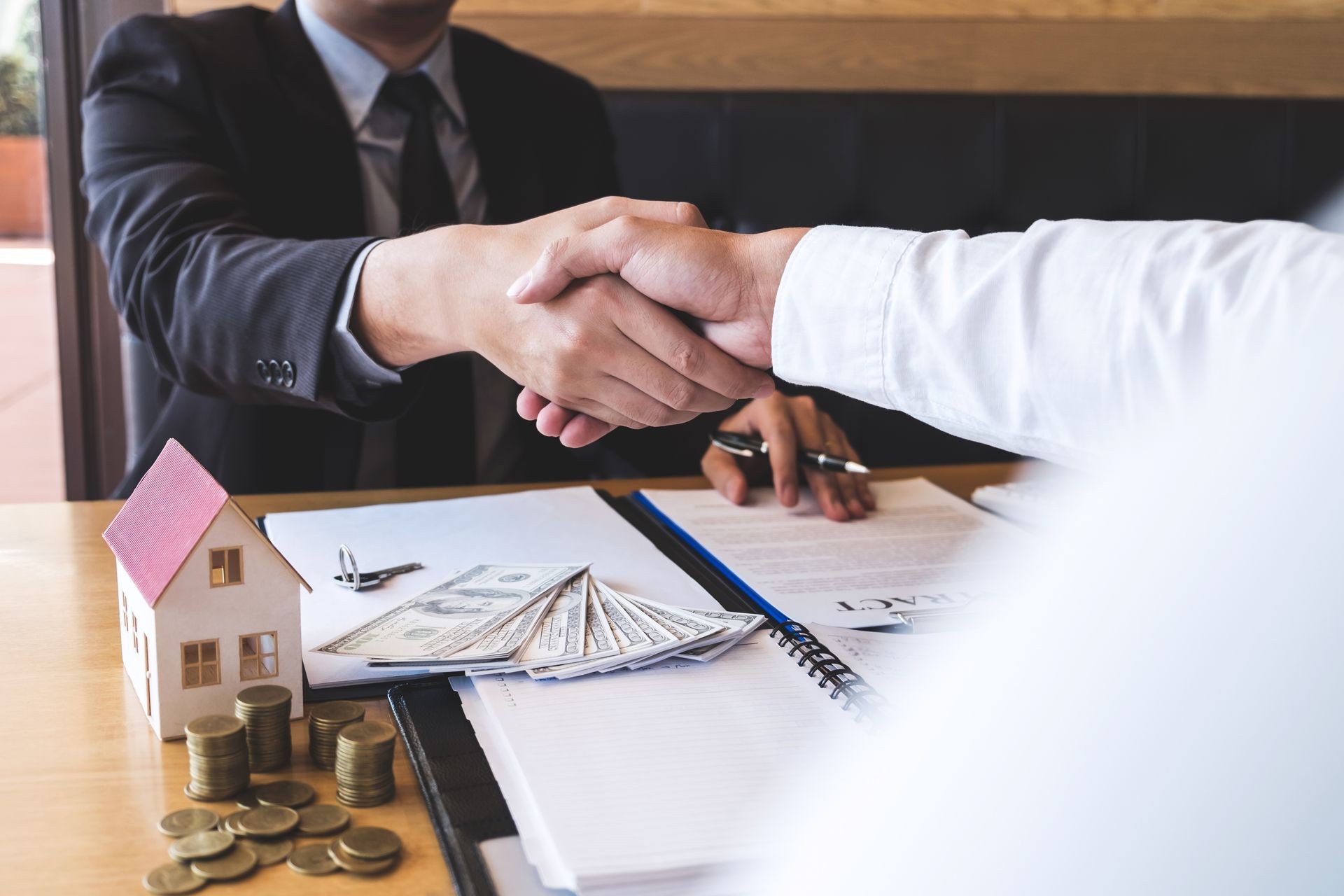 Image of successful deal of real estate, Broker and client shaking hands after signing contract approved application form, concerning mortgage loan offer for and house insurance.
